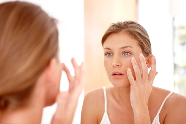 women checking skin on face